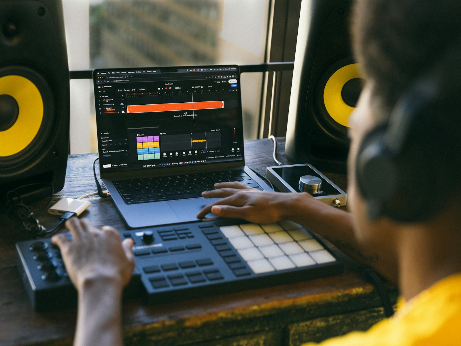 Produzent mit Kopfhörern am MIDI Controller